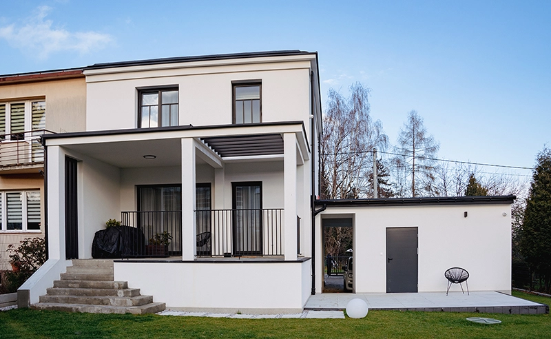 Dom po przebudowie – taras i wiata garażowa w nowoczesnym stylu.