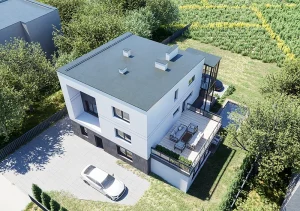 Widok z lotu ptaka na rozbudowaną bryłę domu z tarasem i zagospodarowaną działką.